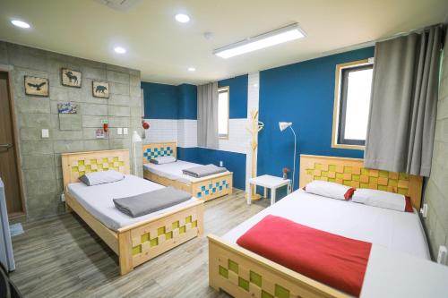 大邱的住宿－大邱中城旅館，一间卧室设有两张床和蓝色的墙壁
