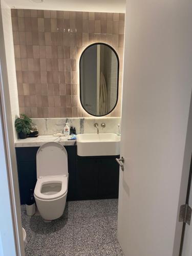 a bathroom with a sink and a toilet and a mirror at Luxury flat Vauxhall in London