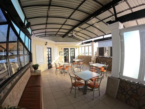 d'une terrasse avec des tables, des chaises et des fenêtres. dans l'établissement HOTEL CASA DE LAS PALOMAS, à Tonalá