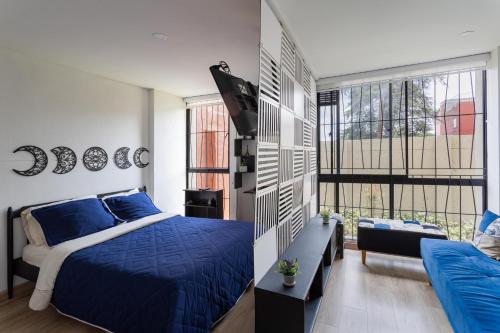 a bedroom with a blue bed and a large window at Apartamento, Centro Histórico, Bogotá in Bogotá