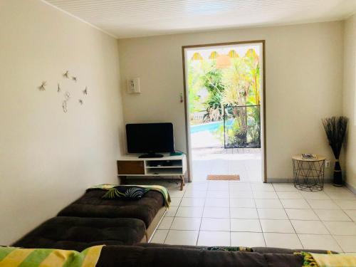a living room with two couches and a door to a patio at Villa TrÔpik Diamond + Bungalow in Le Diamant