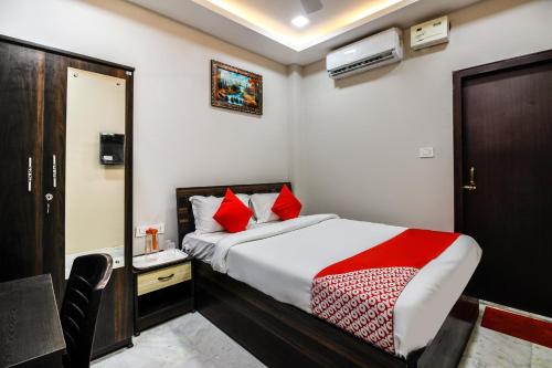 ein Schlafzimmer mit einem Bett mit roten Kissen in der Unterkunft OYO Shiva Guest House in Kamakhya
