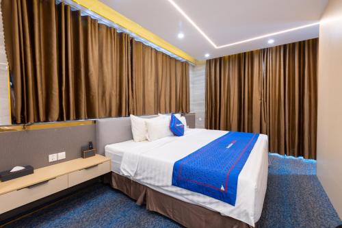 a hotel room with a bed and a large window at Sunshine Hotel Móng Cái in Móng Cái