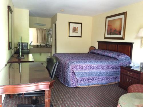 Habitación de hotel con cama y escritorio en Knights Inn Augusta Fort Gordon, en Augusta