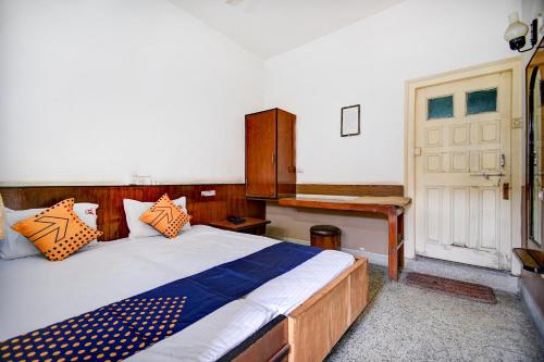 a bedroom with a bed and a wooden desk at SPOT ON Hotel Jd Sons in Nagpur