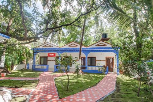 a house with a blue and white facade at OYO Grand Royals Anjuna Near Anjuna Beach in Anjuna