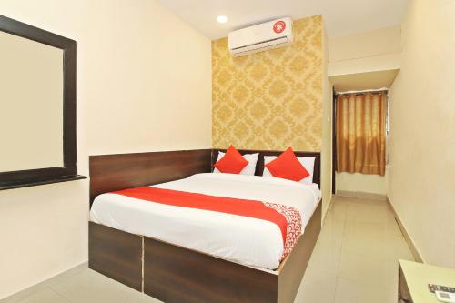 1 dormitorio con 1 cama con almohadas rojas en OYO Vasundhara Guest House Near Tankbund, en Secunderābād