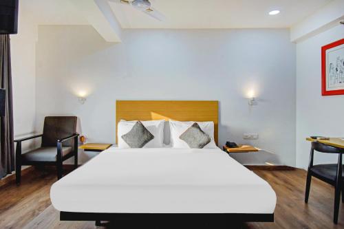 1 dormitorio con 1 cama blanca grande y escritorio en Townhouse The Royal Retreat en Garui
