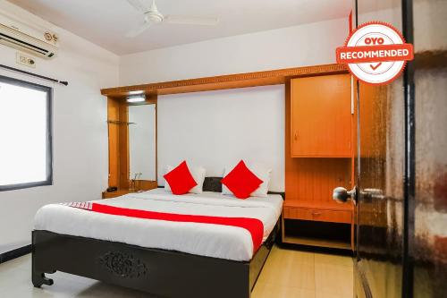a bedroom with a large bed with red pillows at Flagship Hotel Maruthi Gandhi Park in Coimbatore