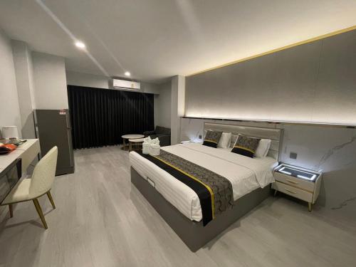 a large bedroom with a large bed and a desk at Berich Hotel in Tak