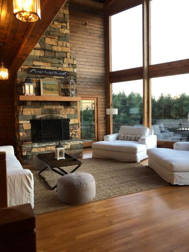 a living room with white furniture and a stone fireplace at Country vacation home 