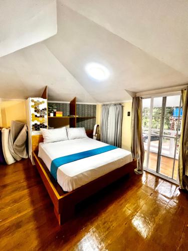 a bedroom with a large bed and a large window at The Bleu Mansion Iligan in Iligan City