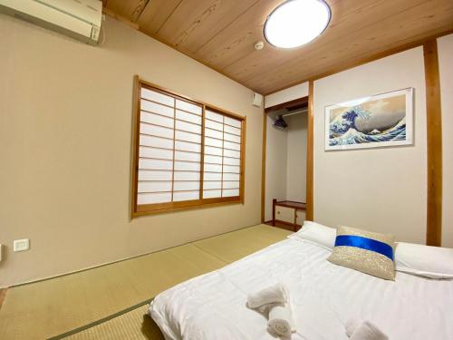 1 dormitorio con 1 cama en una habitación con ventana en D27-Outstanding convenience 4DK/ Shinjuku Okubo en Tokio