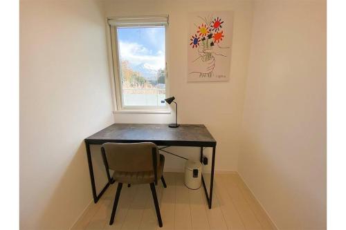 a desk with a chair in front of a window at Mt Fuji koko 新築貸別荘 富士山一望 BBQ お得な週割月割 in Fujikawaguchiko