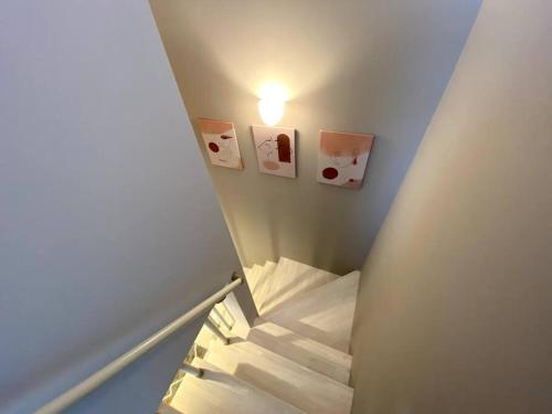 a stairway with a light and pictures on the wall at Mt Fuji koko 新築貸別荘 富士山一望 BBQ お得な週割月割 in Fujikawaguchiko