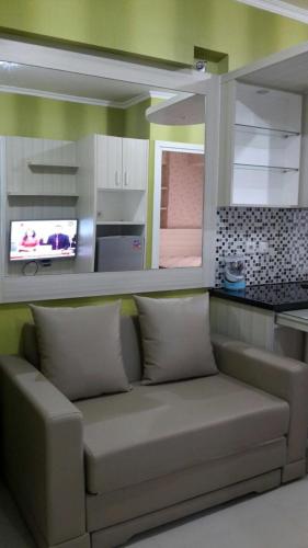 un soggiorno con divano e una cucina di Apartement green pramuka city by Femi a Giacarta