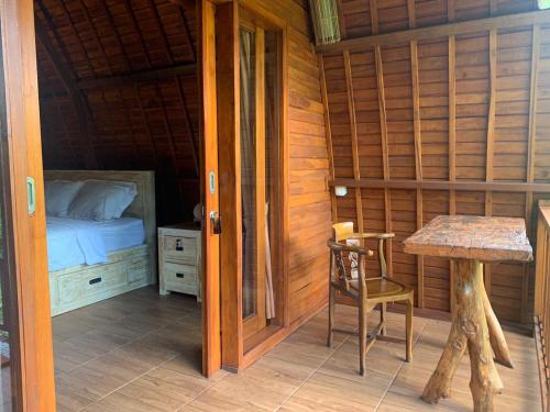 een kamer met een bed en een tafel in een kamer bij Sugita Wooden House in Payangan