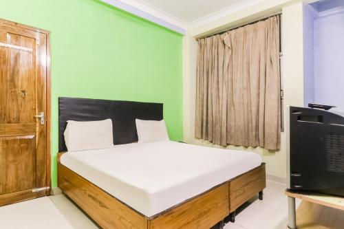 um quarto com uma cama e uma televisão em OYO Flagship Hotel Digantika em Bālugān