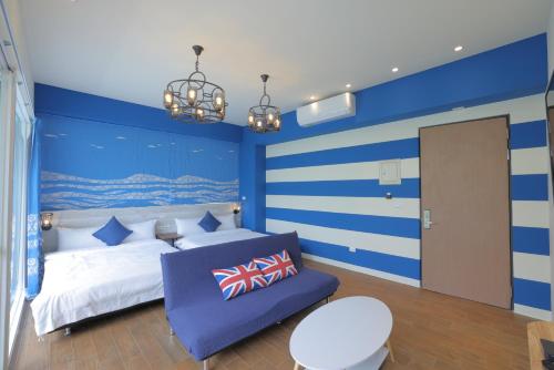 a blue and white bedroom with a bed and a chair at 去七星潭-海景電梯民宿Qixingtan in Dahan