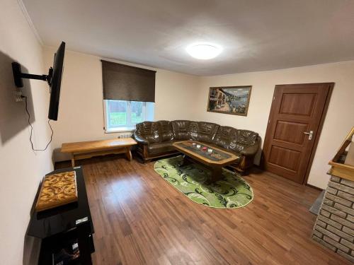 a living room with a leather couch and a table at Оренда будинку з банею на дровах в с. Фастівец, Фастівського району в 45 км. від м. Київ in Fastovets