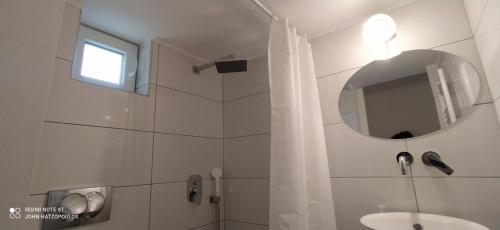 a white bathroom with a sink and a mirror at Peaceful Home in Thessaloniki