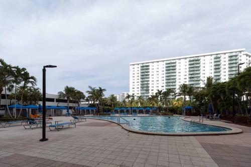 una piscina en un complejo con un gran edificio en Modern Oceanview Condo - Steps to the Beach!, en Miami Beach