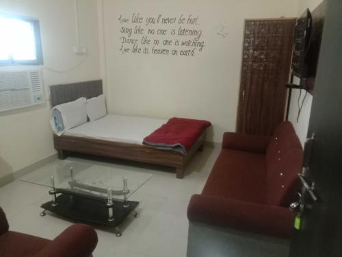 a living room with a bed and a couch at OYO Raj Villas in Satna