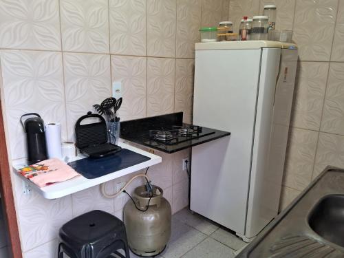 a small kitchen with a white refrigerator and a sink at Edward Suíte Manaus 01 in Manaus