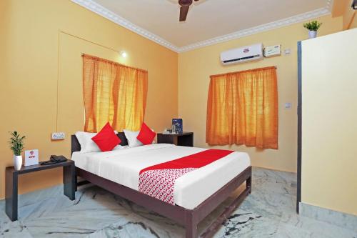 een slaapkamer met een groot bed met rode kussens bij OYO Flagship Advik Cottage in Khandagiri