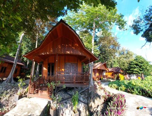 uma pequena casa de madeira com um alpendre em Maratua Blue Resort em Maratua Atoll