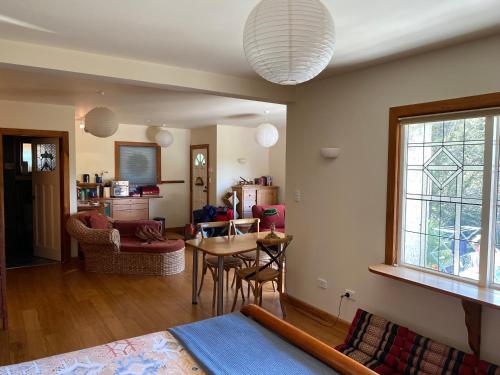 a living room with a table and a dining room at Joya Garden & Villa Studios in Nelson