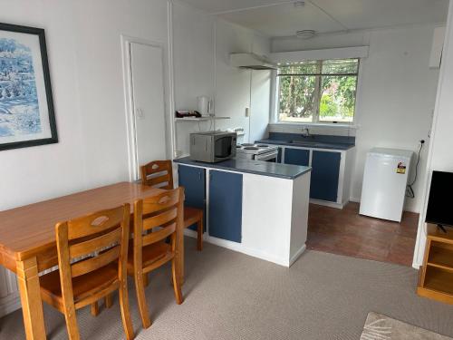 una pequeña cocina con mesa y microondas en MALFROY Motor Lodge Rotorua, en Rotorua