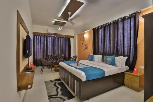 a bedroom with a bed and a living room at Hotel Siddharth Inn in Gandhinagar