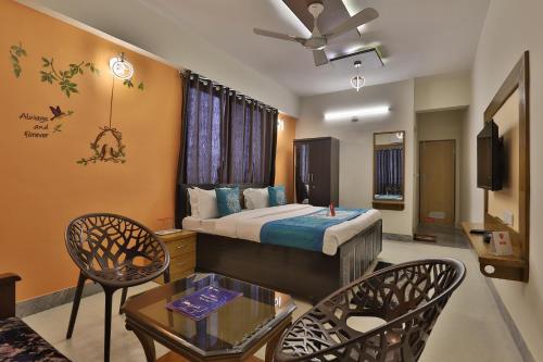 a hotel room with a bed and a table and chairs at Super OYO Hotel Siddharth Inn in Gandhinagar