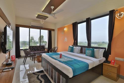 a bedroom with a large bed in a room with windows at Super OYO Hotel Siddharth Inn in Gandhinagar