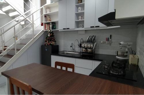 a kitchen with a table and a christmas tree in it at Rumah Bahagia 36 in Bonorejo