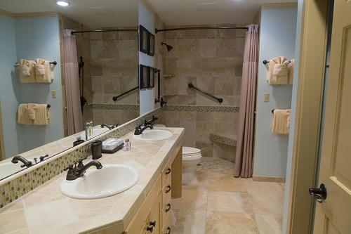 a bathroom with two sinks and a shower at Inn at Spanish Head Resort Hotel in Lincoln City