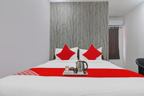 Habitación de hotel con cama con almohadas rojas en Super OYO Alwal Residency, en Hyderabad