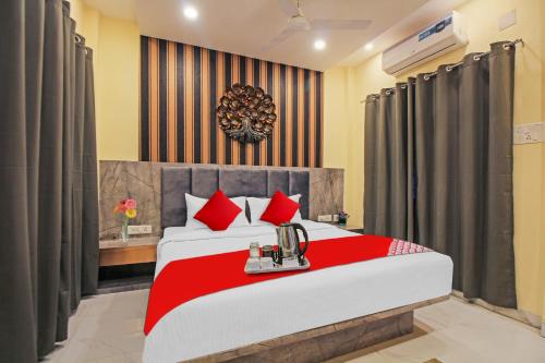 a bedroom with a large bed with red pillows at Avenue Inn Near Birla Mandir in Kolkata