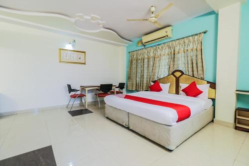 拉賈蒙德里的住宿－Parnasala Princely，配有一张床和一张书桌的酒店客房