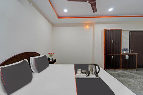um quarto com uma cama grande e uma mesa com uma chaleira. em Capital O Hotel Lakshmi Residency em Tirupati