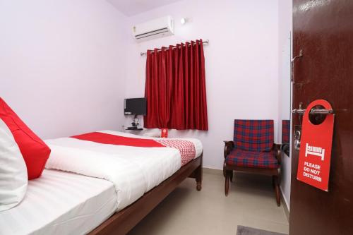 a bedroom with a bed and a red curtain at Collection O Aditya Inn in Jamshedpur