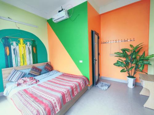 a bedroom with a bed with colorful walls at Sa Mộc House Tam Đảo - Venuestay in Vĩnh Phúc