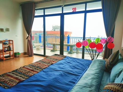 a living room with a couch and a large window at Sa Mộc House Tam Đảo - Venuestay in Vĩnh Phúc