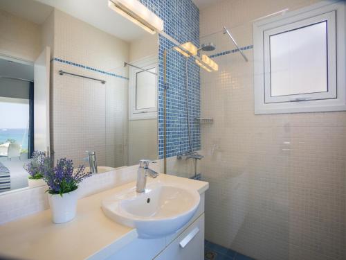a bathroom with a sink and a shower and a mirror at Protaras Seafront Villa Sirina Pearl in Protaras