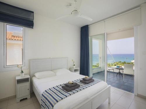a bedroom with a bed and a view of the ocean at Protaras Seafront Villa Sirina Pearl in Protaras