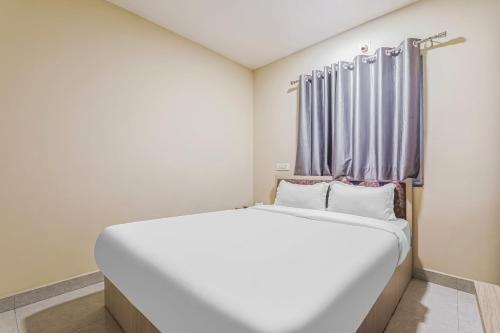 een wit bed in een kamer met een raam bij Super OYO Hotel Rameshwar in Rānchī