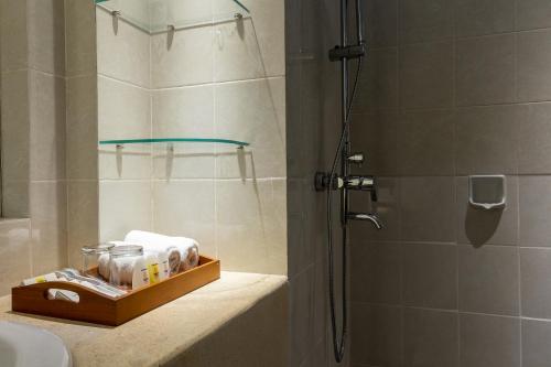 a bathroom with a shower stall and a sink at Fourteen Roses Beach Hotel in Legian