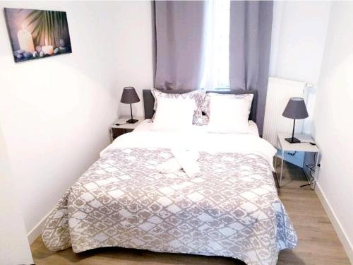 - une chambre avec un grand lit blanc et deux lampes dans l'établissement City Brussels Apartments, à Bruxelles