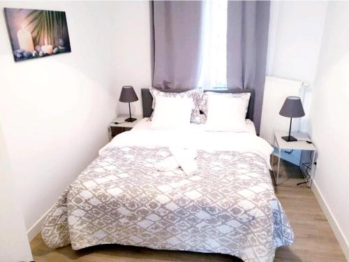 ブリュッセルにあるCity Brussels Apartmentsの大きな白いベッドと2つのランプのある寝室